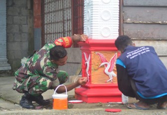  Babinsa Koramil 1710-02/Timika saat Cat Gapura di Kampung Mawokau Jaya