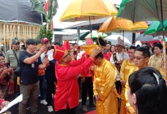 Walikota Bitung saat di pakaikan penutup kepala oleh ketua panitia pelaksana