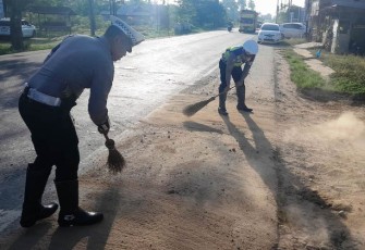 Anggota Satlantas Polres Aceh Timur Bersihkan Material Kerikil di Jalan