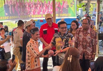 Wali Kota Bitung Maurits Mantiri saat membagikan daging sapi