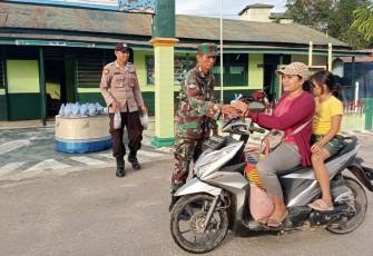 Babinsa Koramil Kahut dan Bhabinkamtibmas saat Bagikan Takjil Gratis Kepada Masyarakat