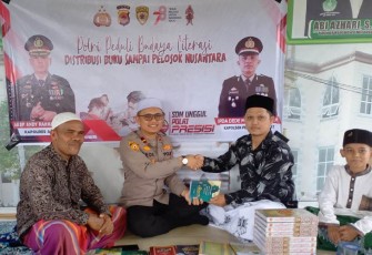 Kapolsek Peureulak Barat saat Bagikan 105 Al Quran dan Kitab