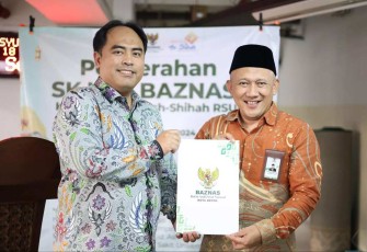 Ketua BAZNAS Depok, Endang Ahmad Yani (kanan) saat menyerahkan SK pembentukan UPZ RS UI