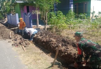 Babinsa Koramil Kebonsari saat Gotong Royong Bersama Warga Perbaiki Saluran Drainase