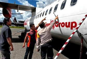 Polisi saat menunjukan titik tembak di badan pesawat Wings Air setelah mendarat aman di Bandara Nop Goliat Dekai, Kabupaten Yahukimo Papua, Sabtu (17/2). 