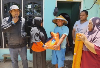 Kepala Dinas BPBD Kabupaten Bintan Romlah saat menyerahkan Bantuan pada Masyrakat tertimpa musibah  dampak hujan dan  angin kencang menghatam rumah warga