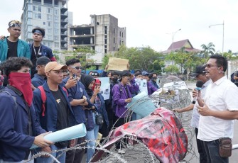 Direktur Pelayanan Terpadu Satu Pintu, Harlas Buana saat menemui puluhan mahasiswa yang menggelar aksi unjuk rasa di gerbang masuk BP Batam, Senin (23/12/2024). 