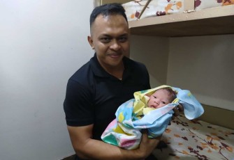 Letda Laut (K) dr Riezqi Bakrie menggedong bayi pasca persalinan 