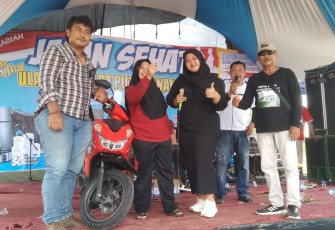 Maulana Rohman Sidiq saat menyerahkan hadiah kejutan utama berupa sepeda motor kepada peserta jalan sehat yang digelar dalam rangka perayaan hari lahir pengusaha muda itu.