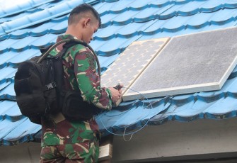 Satgas 330 Tri Dharma saat memasang lampu solar cell 
