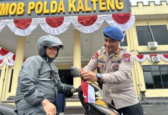 Brimob Kalteng Bagikan Ratusan Bendera Merah Putih ke Pengguna Jalan Raya