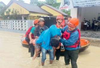 Petugas BPBD Kabupaten Pandeglang saat mengevakuasi salah seorang warga yang terdampak banjir