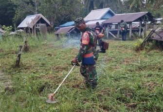 Babinsa Koramil Kokonao saat Bersihkan Area Pemakaman Umum