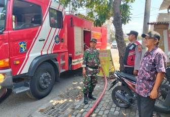 Sertu Nursolichin bersama Damkar saat padamkan kebakaran warung di wilayah binaan, Kamis (23/10)