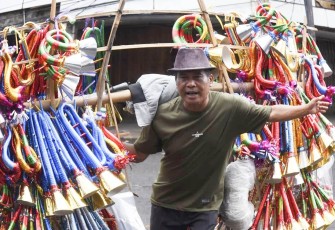 Nuryaman pedagang terompet kertas asal Cikarang saat berjualan di jalan Pinangsia, Pasar Pagi, Glodok, Jakarta, Rabu (31/12)
