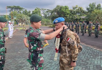 Danyonkes 2 Kostrad Letkol Ckm dr. Ucok Harianto mengalungkan bunga purna tugas Sertu Priyan Setyawan, Senin (28/4)