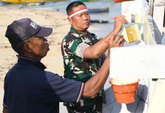 Danrem 083/Bdj Kolonel Inf Kohir saat mengecat perahu nelayan dalam aksi produktif di pantai Sendang Biru, Kabupaten Malang, Sabtu (2/8)