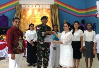 Danpos Auren, Letda Arm Hafidz Syahrafi menyerahkan buku natal dan alkitab 