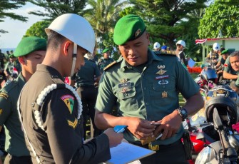 Komandan Pomdam XVIII/Kasuari, Kolonel Cpm M. Rokib Jabar, S.H., saat melaksanakan kegiatan pembagian helm standar dan pemeriksaan kendaraan bermotor kepada prajurit dan PNS Kodam XVIII/Kasuari, bertempat di Lapangan Makodam XVIII/Kasuari, pada Rabu (20/8/2025).
