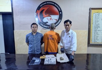 Tersangka (tengah) beserta barang bukti saat diamankan