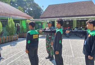 Anggota Posramil Pitu Kodim 0805/Ngawi Serma Eko Prayitno  melaksanakan Pelatihan Baris Berbaris kepada anggota Banser bertempat di Desa Ngancar Kecamatan Pitu, Minggu (23/02/2025)