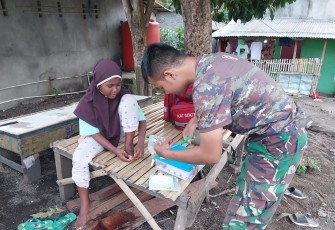 Tim kesehatan satgas TMMD Ke-123 Kodim 1310/Bitung saat memberikan pertolongan pertama pada seorang anak yang mengalami kecelakaan saat bermain