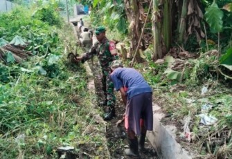 Babinsa Kelurahan Sogaten, Koramil 0803-02/Madiun, Serka Rofik Sutrisno, bersama warga RT 02 RW 01 saat melaksanakan kerja bakti pembersihan saluran air.