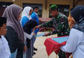 Sertu Sholeh memberikan santunan untuk siswa 