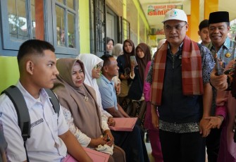 Pepi Mulyasari (berbaju abu-abu, kanan) sedang mendaftarkan putranya ke SLBN 1 Padang