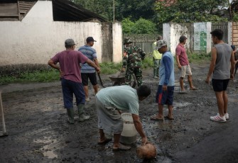Sertu Aris Setiawan anggota Koramil Tipe B 0807/05 Ngunut, bersama masyarakat melaksanakan kegiatan kerja bakti pengecoran jalan berlubang di Desa Sumberingin Kidul, Kecamatan Ngunut, Kabupaten Tulungagung, Jumat (06/03/2026)