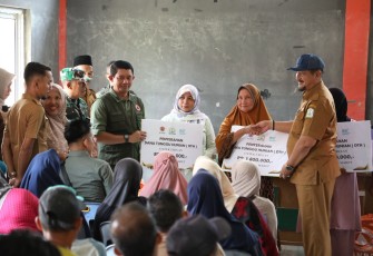 Kepala BNPB Letjen TNI Dr. Suharyanto, S.Sos., M.M (baju rompi hijau ) dan Bupati Aceh Tamiang  Armia Pahmi saat menyerahkan bantuan dana tunggu hunian (DTH) kepada warga yang terdamapk bencana di Kecamatan Rantau , Kabupaten Aceh Tamiang, pada Selasa (10/3)
