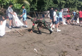 Personil Kodim 1310/Bitung bersama warga dan para siswa saat melaksanakan pembersihan Pantai