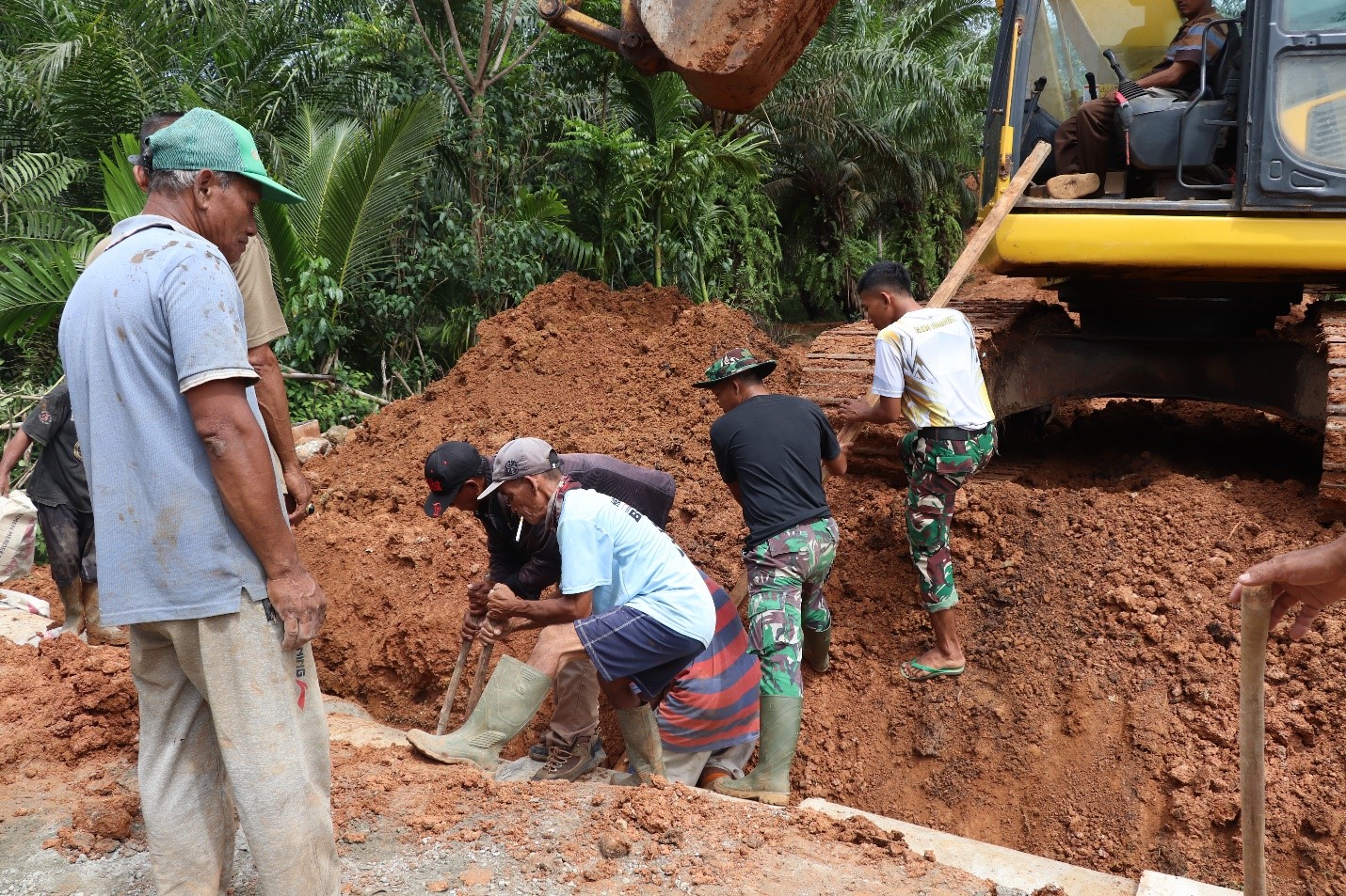 Menguras tenaga, Satgas TMMD dibantu masyarakat melakukan penyusunan gorong-gorong secara presisi.