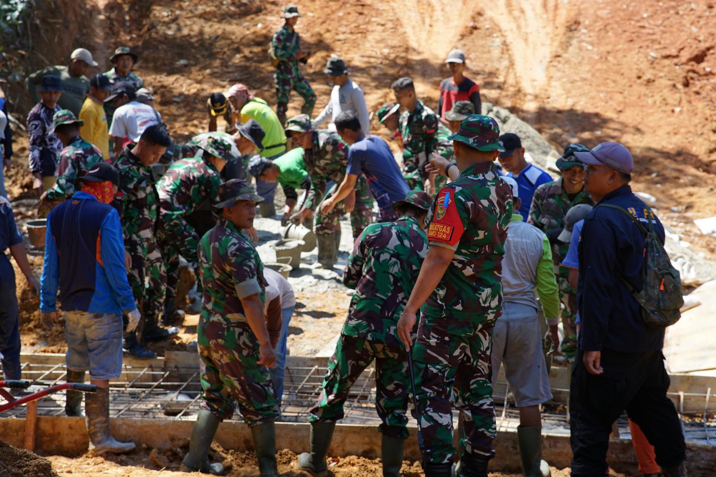 Dansatgas 0408/BS Letnan Kolonel Czi Bambang Santoso meninjau pengecoran plat duiker, memastikan pengerjaan sesuai spek.