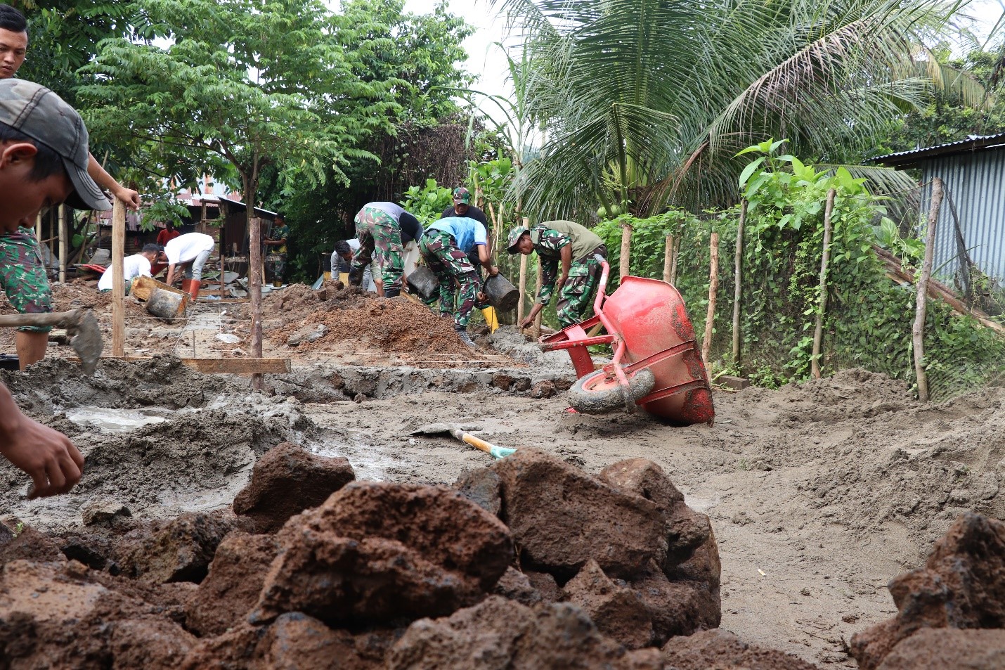 Satgas TMMD bersama masyarakat berjibaku memasang pondasi rehab RTLH.