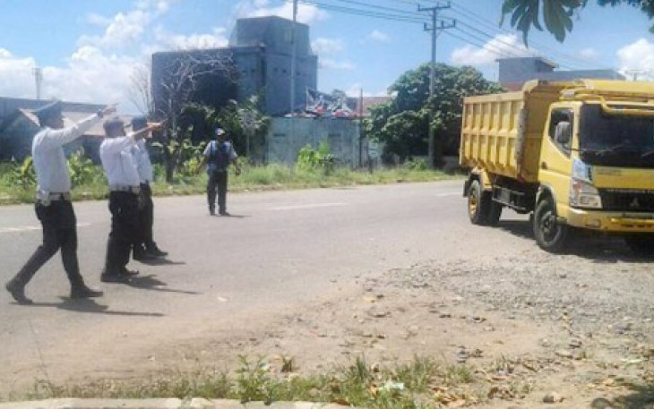Petugas Dishub saat mengarahkan kendaraan angkutan barang untuk masuk ke Terminal Sungai Hitam, Kamis (20/4).