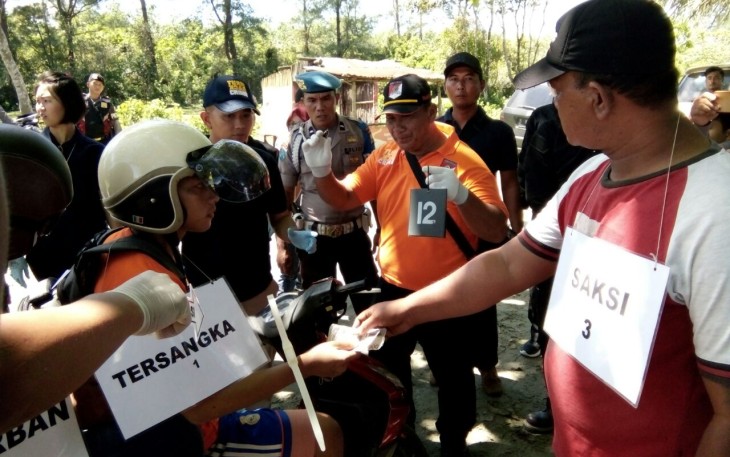Tersangka saat melakukan adegan rekonstruksi di TKP