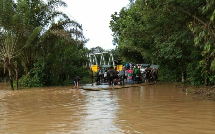Banjir genangi jalan setinggi lutut orang dewasa. Motor terpaksa diangkut pakai rakit