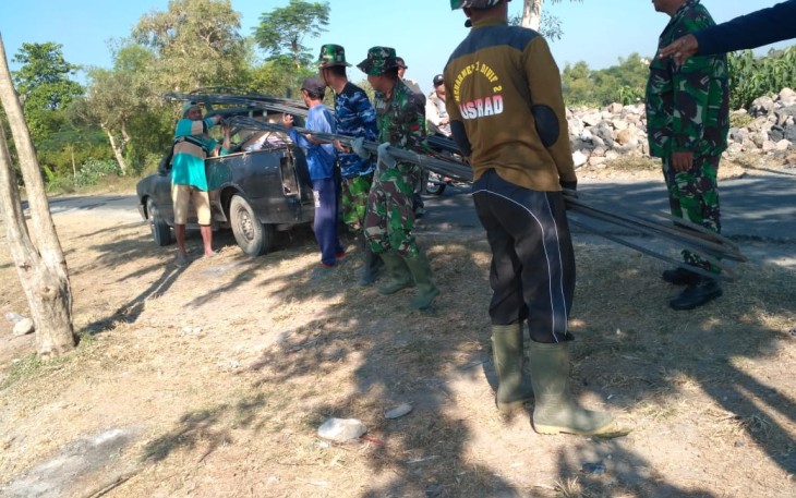 Personil TNI Dan Masyarakat Sedang Menurunkan Besi 