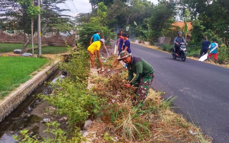 Babinsa Royong Bersihkan Sampah di Sepanjang Jalan