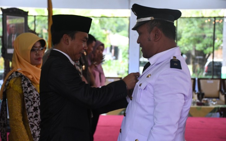 Bupati Wihaji saat menyematkan pin untuk kades terpilih