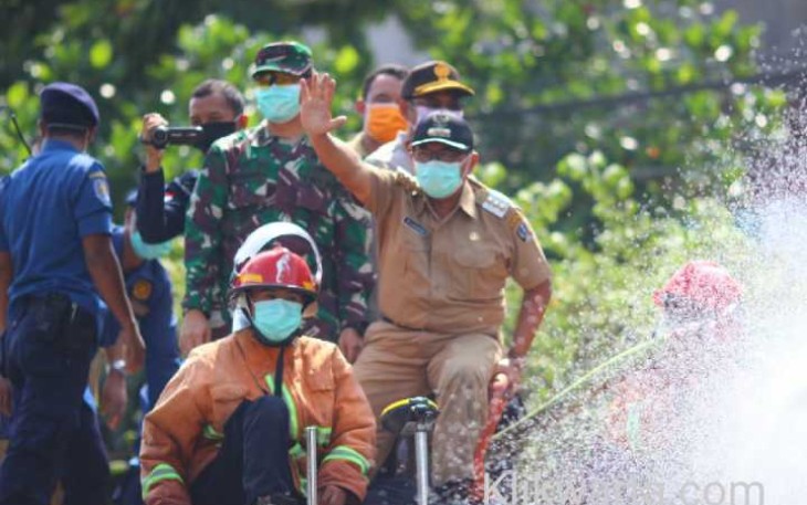 Bupati Blitar Rijanto (melambaikan tangan) saat pimpin penyemprotan Disinfektan diatas truk Damkar