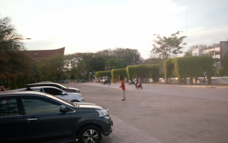 Pengutip Biaya Parkir Mengenakan Baju Merah di depan Mesjid Agung Islamic Center Lhokseuamawe.