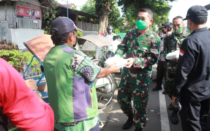 Dandim 0808/Blitar Letkol Inf Kris Bianto saat memberikan Nasi Bungkus ke warga (foto: Istimewa) 