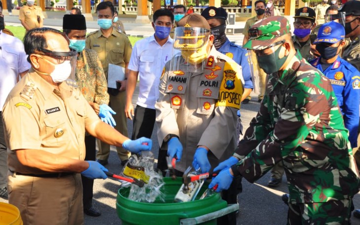 Dandim 0808/Blitar Letkol Inf Kris Bianto saat memusnahkan Botol Miras. (foto : Crew Klikwarta.com) 