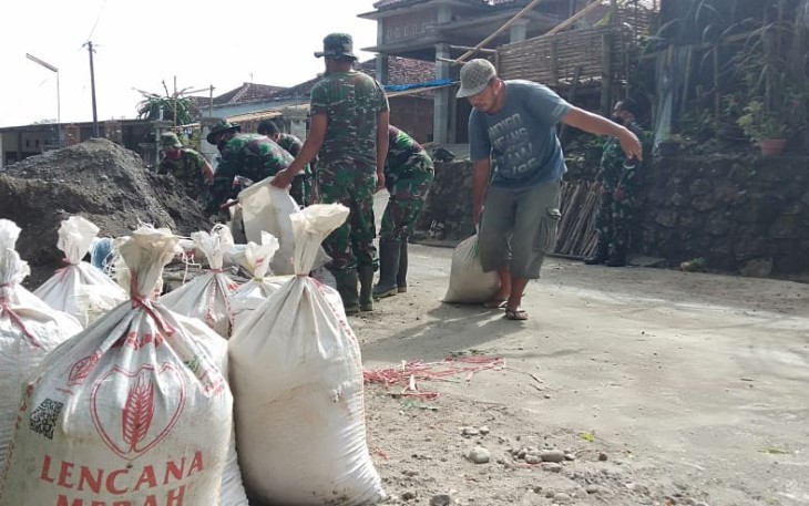 Ketua RW Dusun Ngepoh Bantu TNI Menarik Pasir dengan Karung