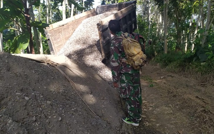 Sertu Miswan Arahkan Penurunan Pasir dari Atas Truk