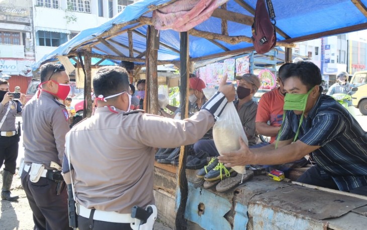 Polisi Bagikan Beras Kepada Masyarakat Kecil