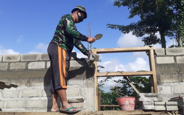 Sertu Jarno Susun Batako dalam Pembangunan Dinding Rumah Karyono