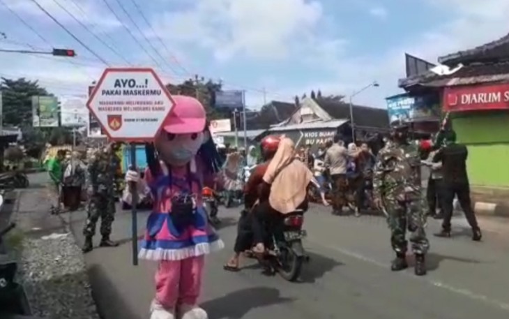Serda Wawan (Babinsa) memakai Costum Boneka saat lakukan operasi Yustisi